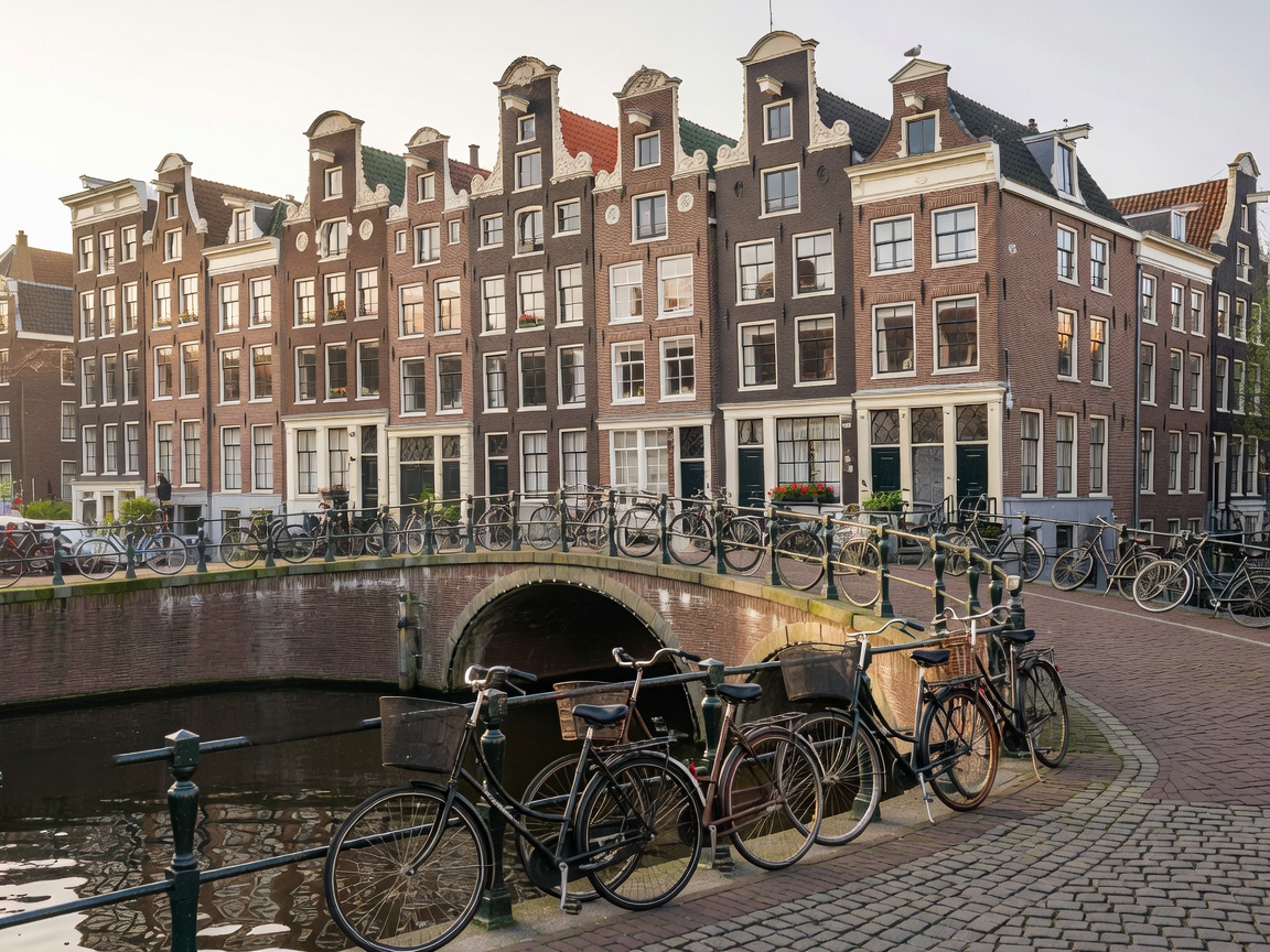 Amsterdam canal houses and bridge with bicycles